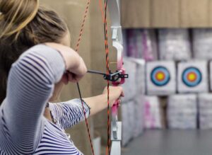Image of girl shooting bow and arrow at archery tournament